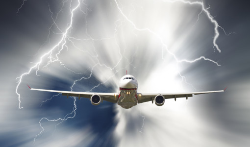 Passenger airplane travelling through sky against stormy bolt cloudscape